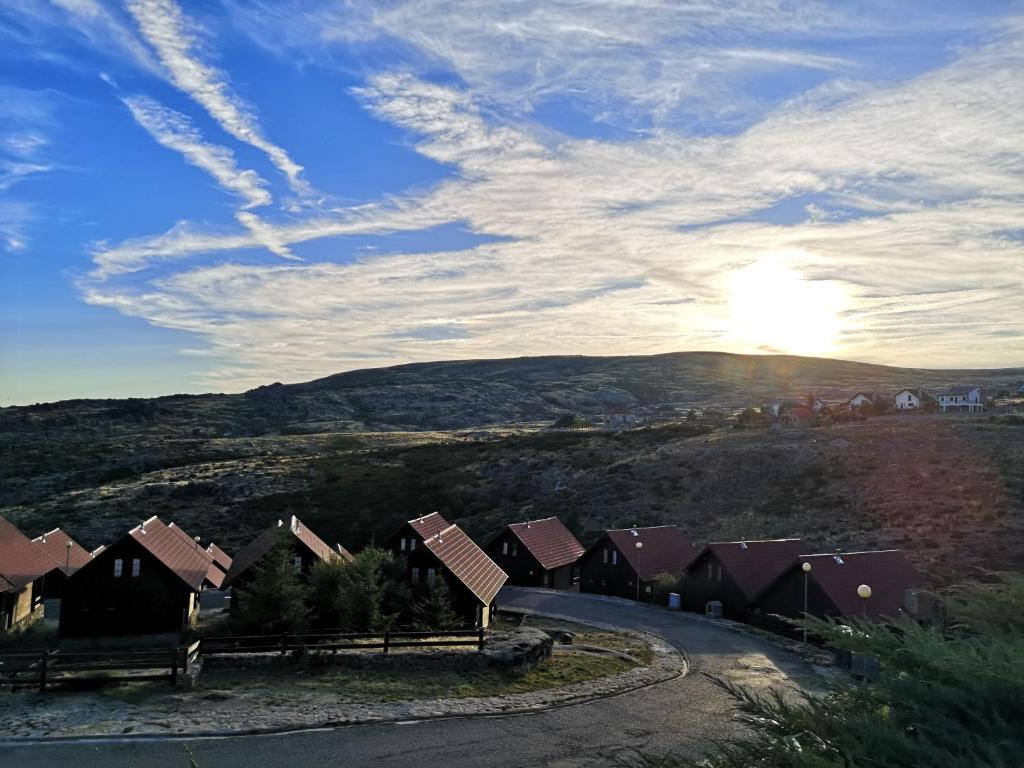 uma casa numa colina com o sol no céu em Mountain Lodge T3 Duplex Abrigo do Lobo na Covilhã
