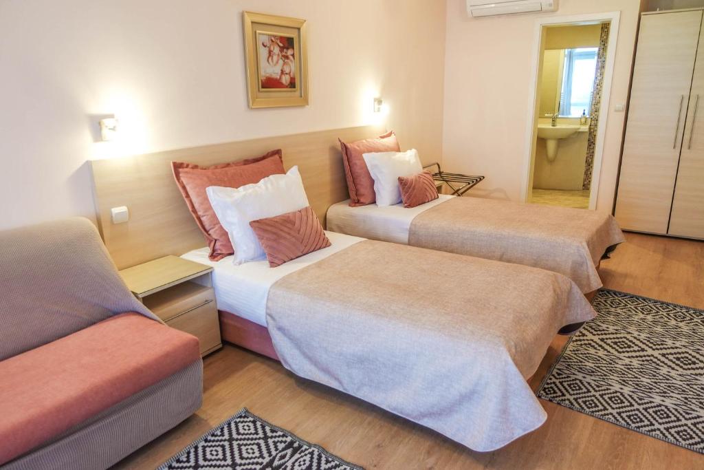 Habitación de hotel con 2 camas y sofá en Hotel Acropolis, en Varna