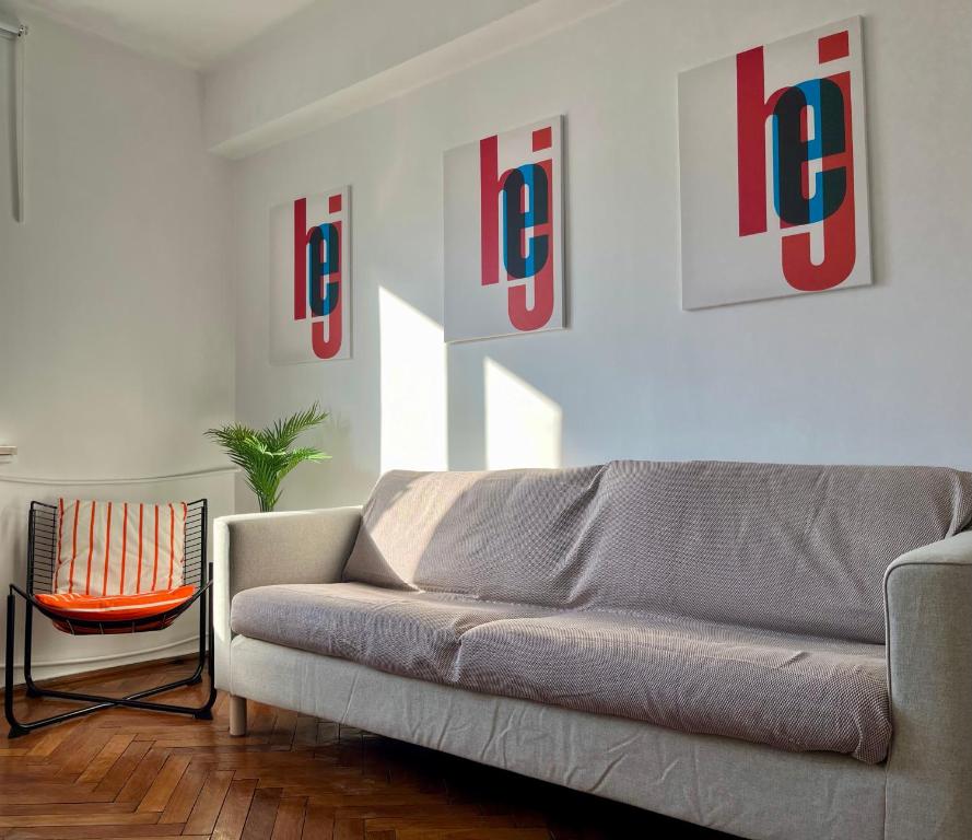 una sala de estar con sofá y algunas fotos en la pared en 2 Bedrooms Apartment In The Heart Of The City, en Craiova