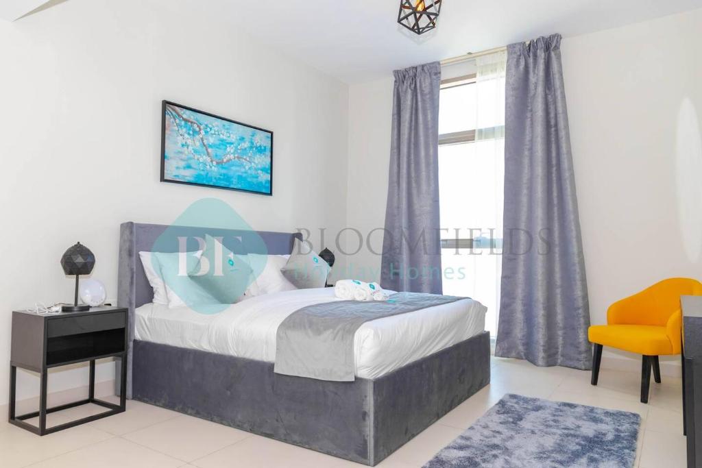 ein Schlafzimmer mit einem Bett, einem Stuhl und einem Fenster in der Unterkunft Modern 1 Bedroom In Reflections in Abu Dhabi