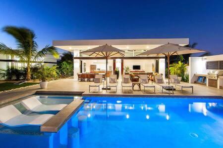 a large swimming pool in front of a house at TOP Rated Private Villa with Pool, Beach Access, Resort Amenities - White Villas v10 in Providenciales