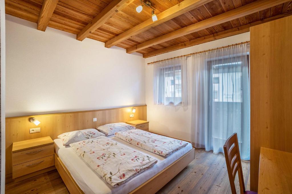 a bedroom with a large bed and a window at Speckign Apartment 3 in Cadipietra