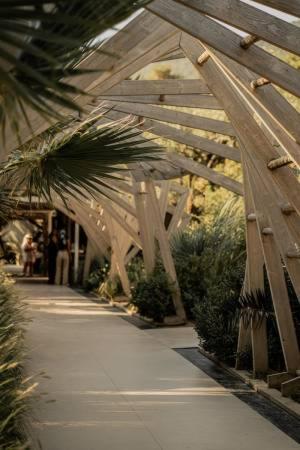 a wooden bridge with palm trees on a sidewalk at Kohylia by La Scala Beach in Limenas