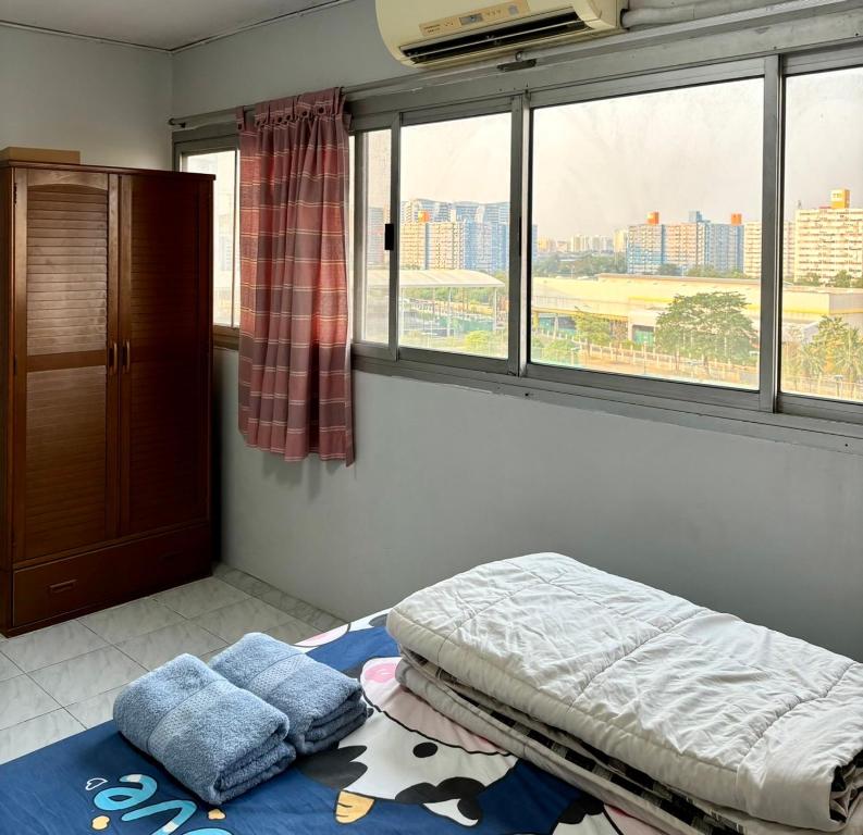 ein Schlafzimmer mit einem Bett und einem großen Fenster in der Unterkunft Popular condo T8 Near Impact. in Thung Si Kan