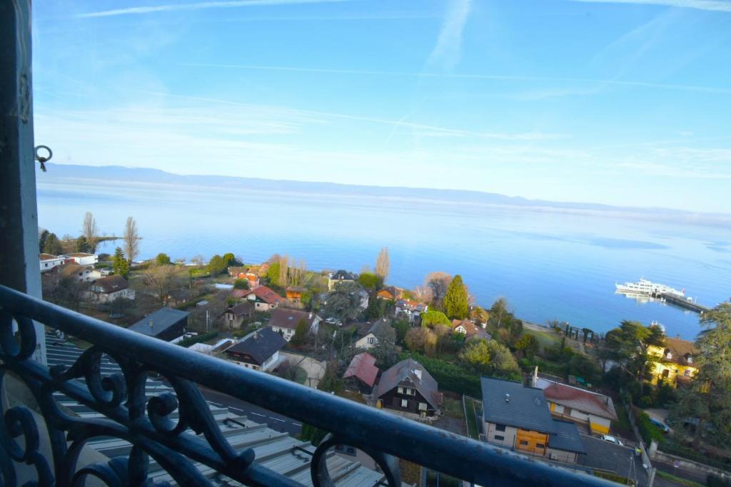 a view of a town and the ocean from a balcony at Appartement avec vue 180 sur le Lac Léman in Thonon-les-Bains