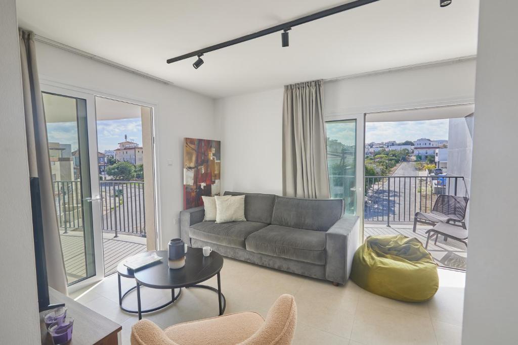 a living room with a couch and a balcony at Eva Residences- Kapparis in Paralimni