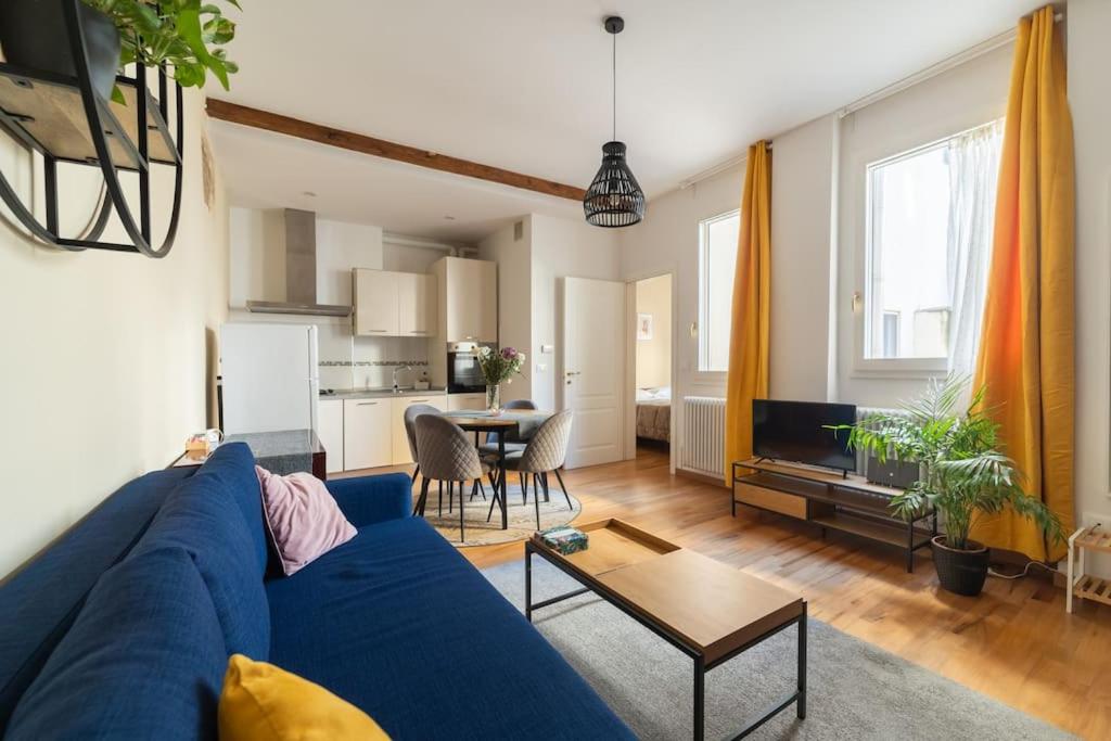 a living room with a blue couch and a kitchen at Borgo dalle Tovaglie in Bologna