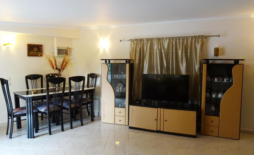 a dining room with a tv and a table with chairs at Nadia's House 2 in Afantou