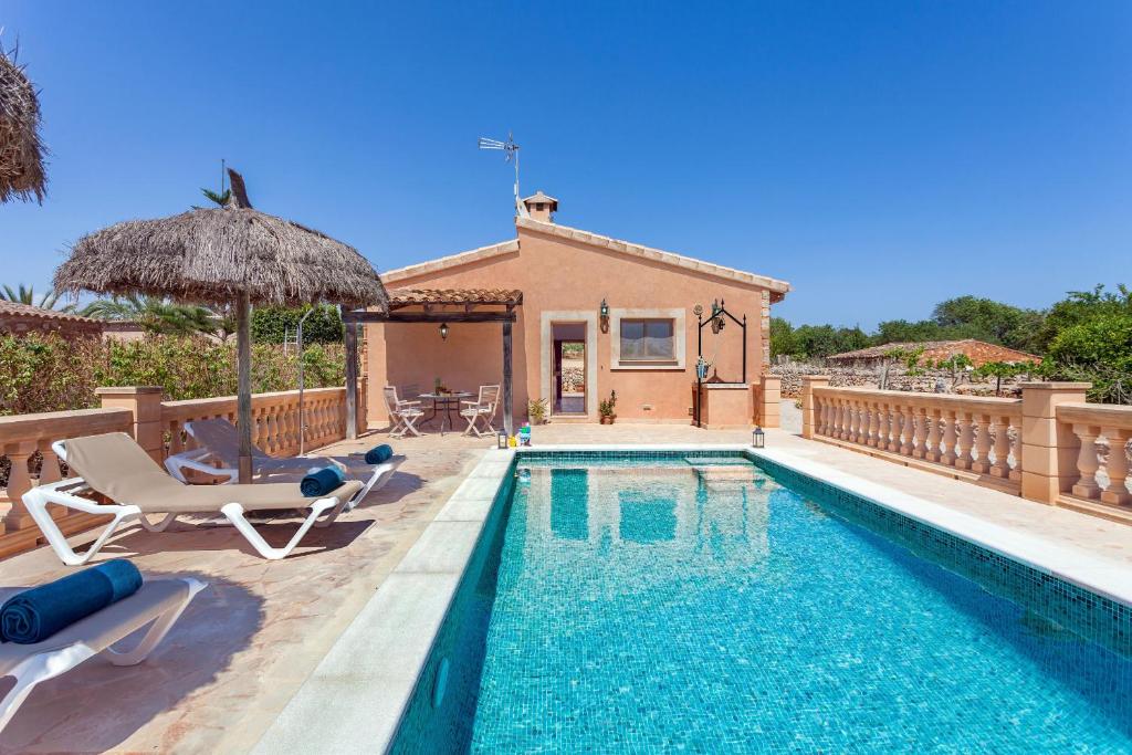 eine Villa mit einem Pool und einem Haus in der Unterkunft Sa Madoneta in Santanyi