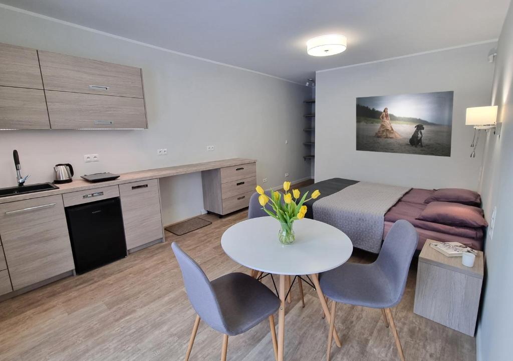 Habitación con cama, mesa y sillas. en Piaskowa 13 - Apartamenty dla Podróżujących bez Dzieci en Nickelswalde