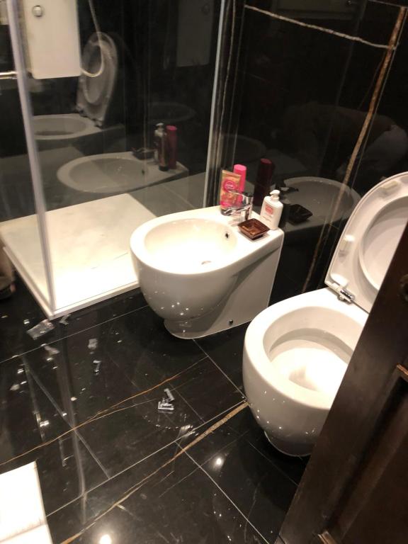La salle de bains est pourvue de toilettes blanches et d'un lavabo. dans l'établissement Casa Begaj, à San Giovanni Valdarno