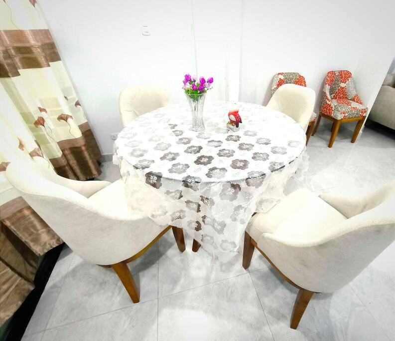 uma mesa branca com cadeiras e um vaso de flores em "Pacae" House em Ica
