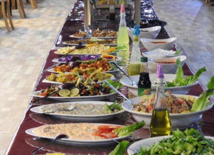 un largo buffet de comida en una mesa larga en Night Magic Camp, en Wadi Rum