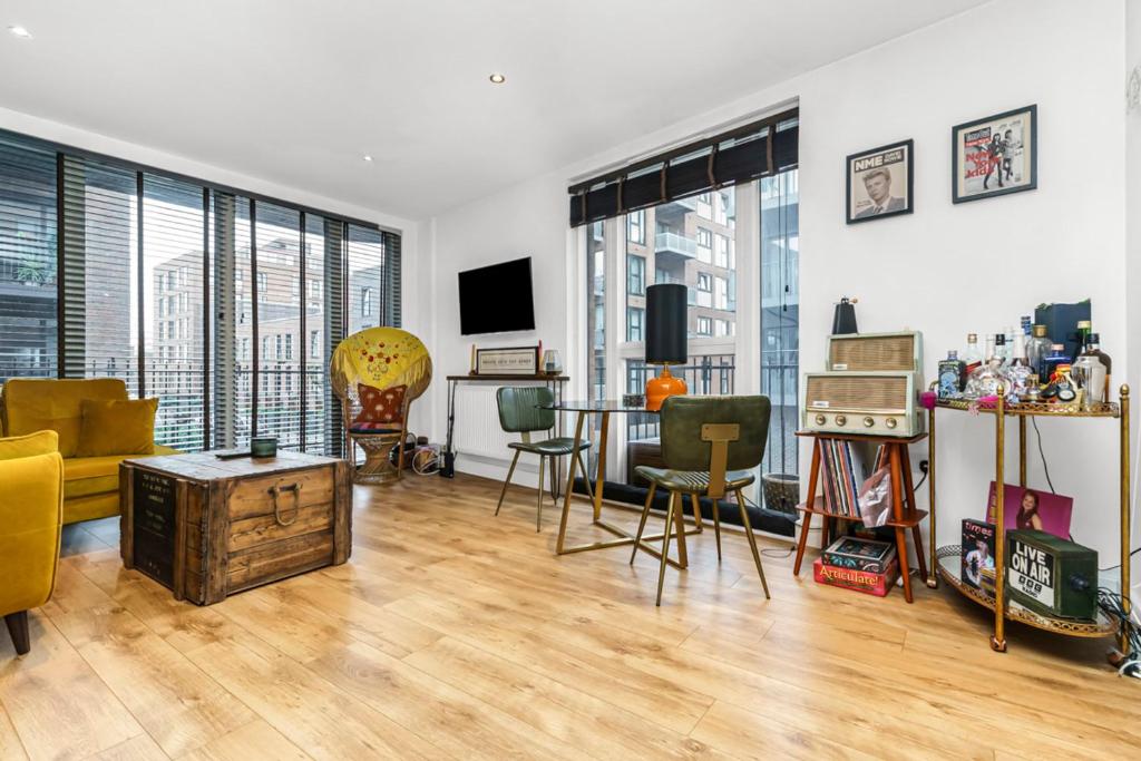 un soggiorno con tavolo e sedie di Chic Urban Apartment In Shoreditch 2 bed 2 bath a Londra