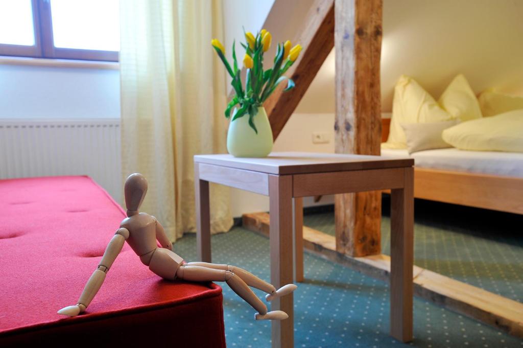 a wooden doll sitting on a table in a room at Pension Schindlau in Scharnstein