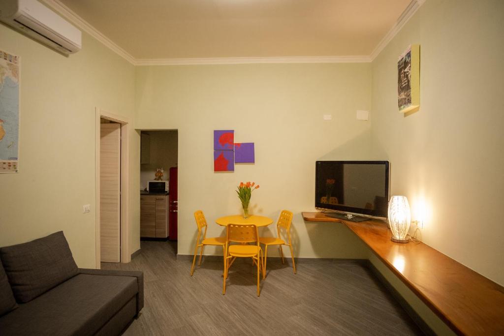 - un salon avec une table et une télévision dans l'établissement Casetta Ponte Milvio, à Rome