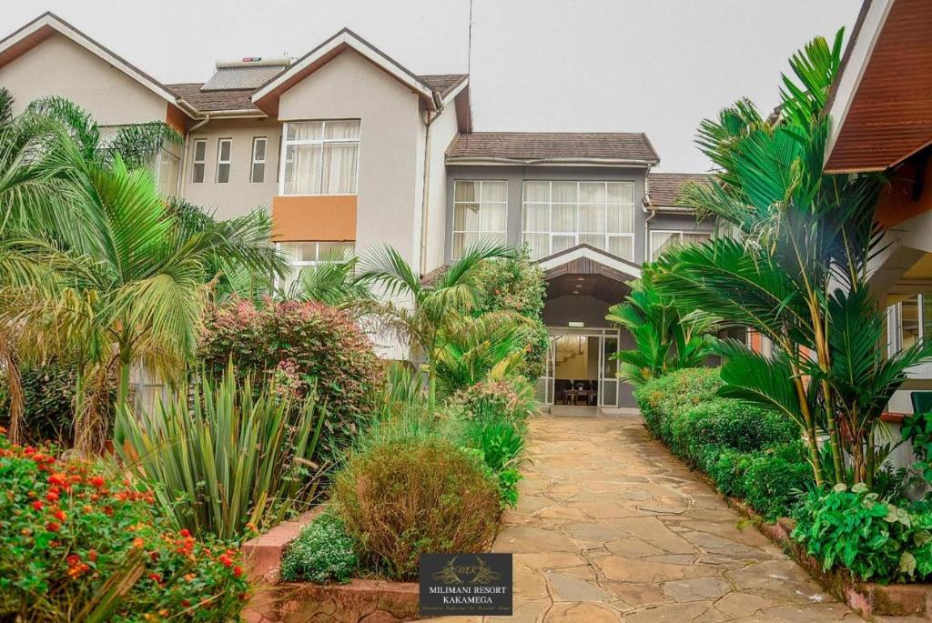 una casa con plantas tropicales delante de ella en Milimani Resort Kakamega, en Kakamega