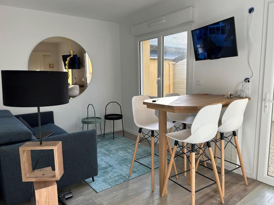 a living room with a table and chairs and a couch at appartement 50 mètres de la mer in Jullouville-les-Pins