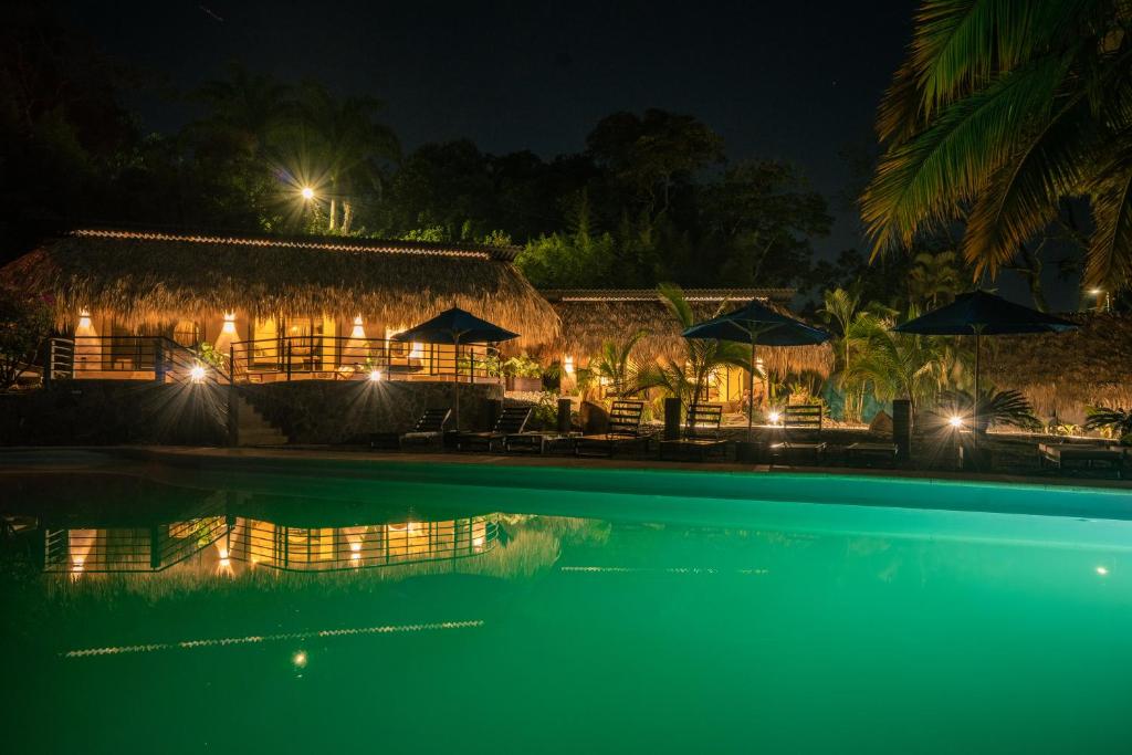 a resort with a swimming pool at night at Jungla EcoLuxury Resort in Villeta