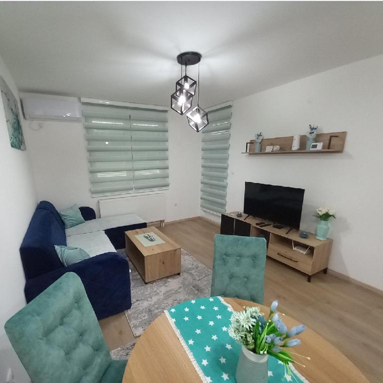 a living room with a couch and a table with chairs at Stan na dan - Apartman Blue Moon in Lukavica