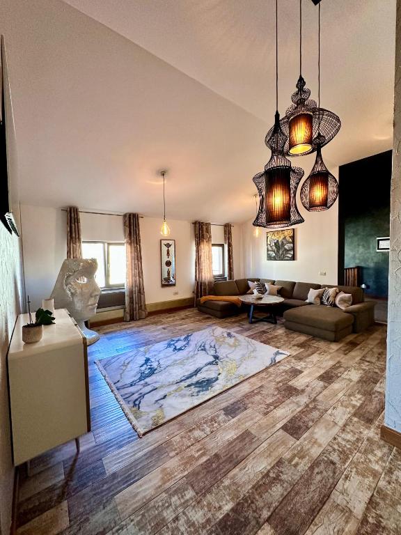 a large living room with a large rug on the floor at Madison Lake Villa in Baloteşti