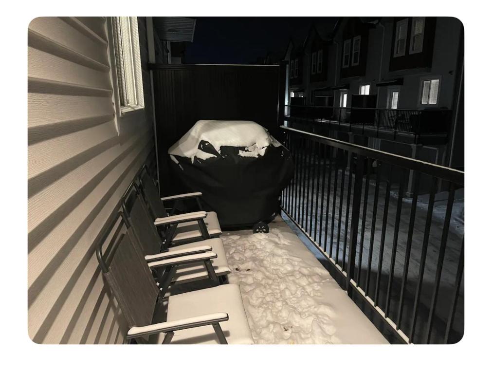 twee stoelen op een balkon met sneeuw erop bij Edmonton in Edmonton