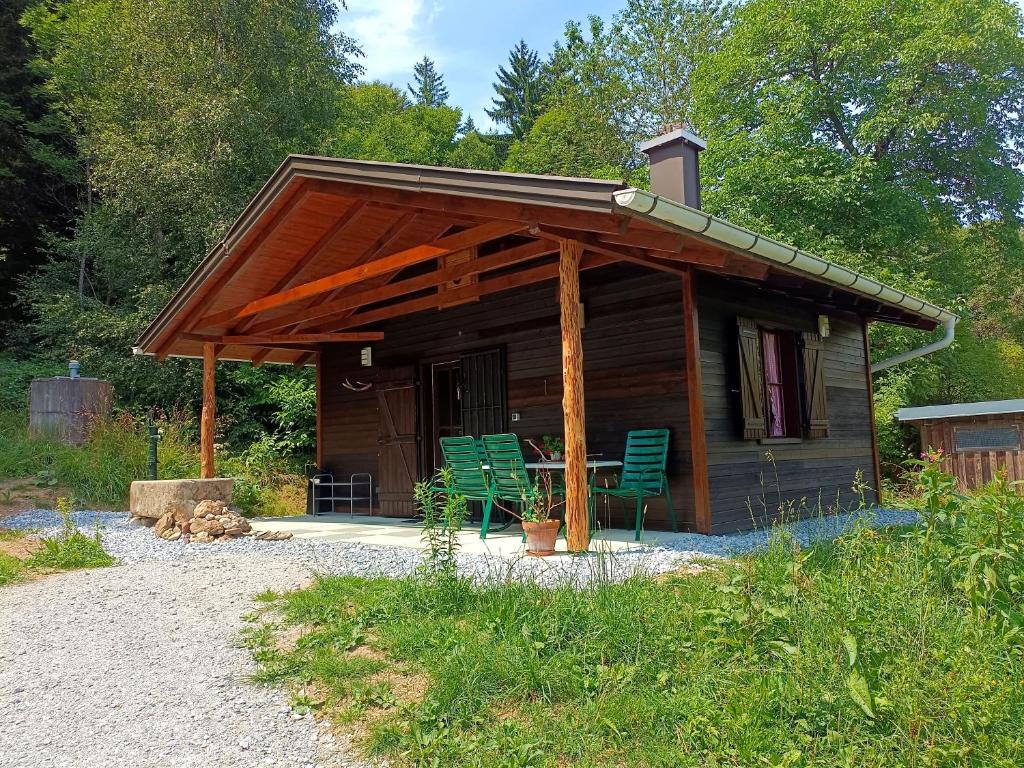 a cabin with two chairs and a table in front of it at Das 1000 Kraut Haus (Berghüttte) in Laimbach am Ostrong