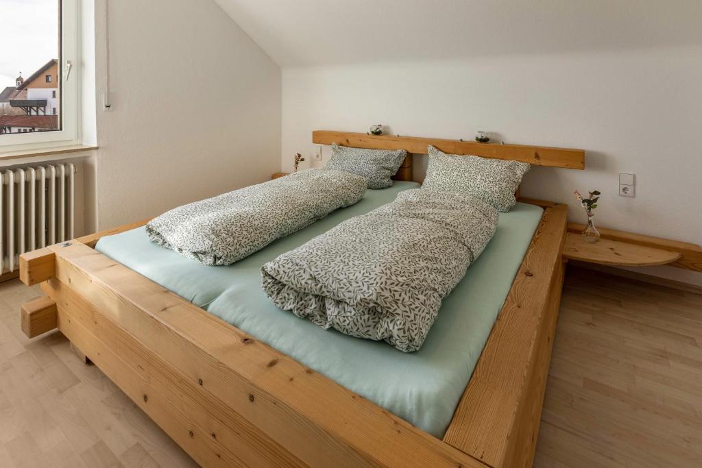 a wooden bed with two pillows on top of it at Ferienwohnung Hüttennest in Villingen-Schwenningen