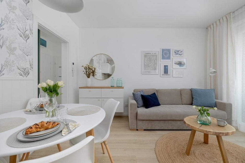 a white living room with a table and a couch at Baltic Marina Residence Studios with Balcony & Pet Friendly by Renters in Kołobrzeg