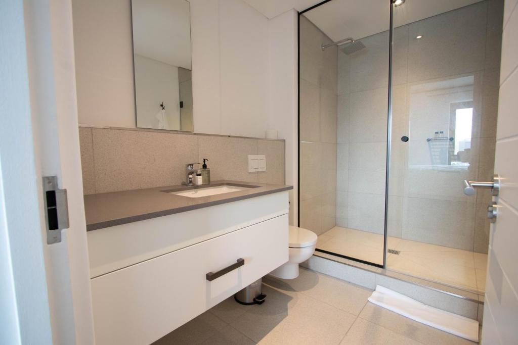 a bathroom with a sink and a toilet and a shower at 9 Palms by Smart City Stays in Cape Town