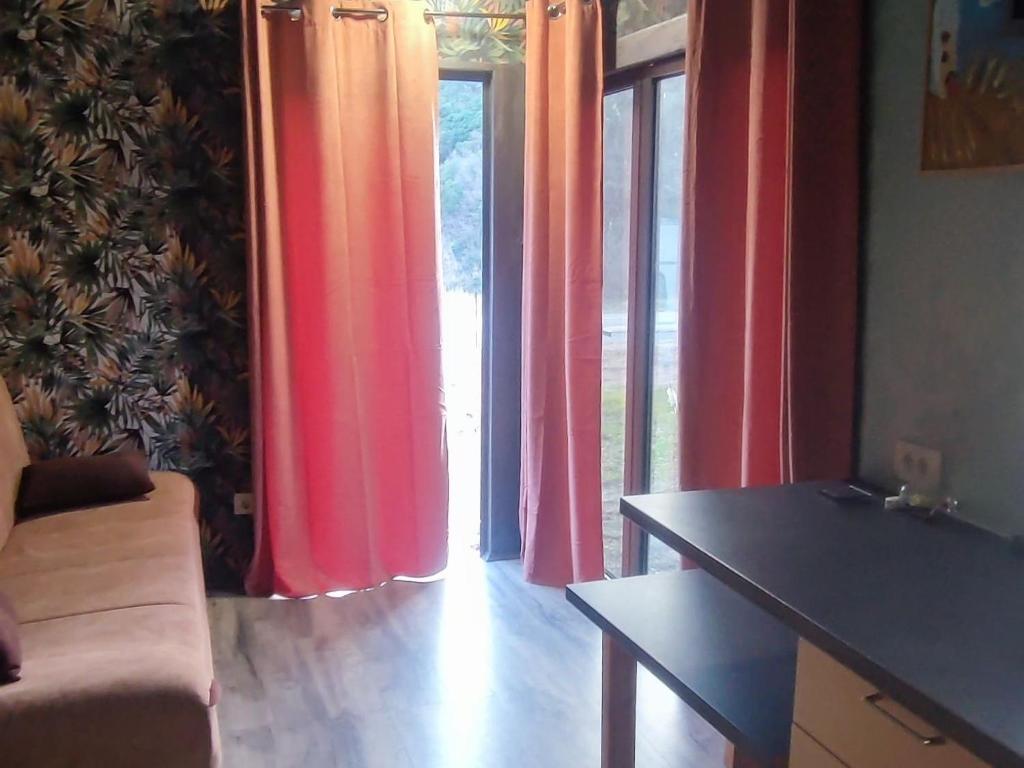 a living room with colorful curtains and a table at Tiny House Montenegro in Petrovac na Moru