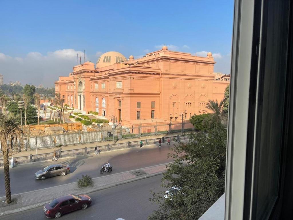 uma vista para um grande edifício laranja com carros numa rua em Museum Plaza no Cairo