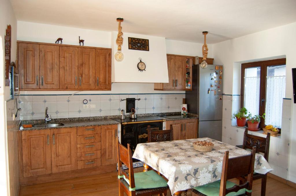 a kitchen with wooden cabinets and a table with a table cloth at Casa en Villa Termal Las Caldas in Las Caldas