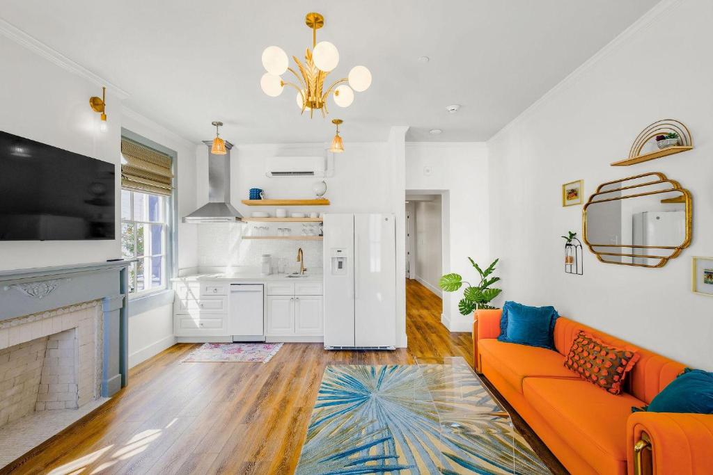uma sala de estar com um sofá laranja e uma cozinha em Old Spanish House- A, The Vivian Suite em Biloxi