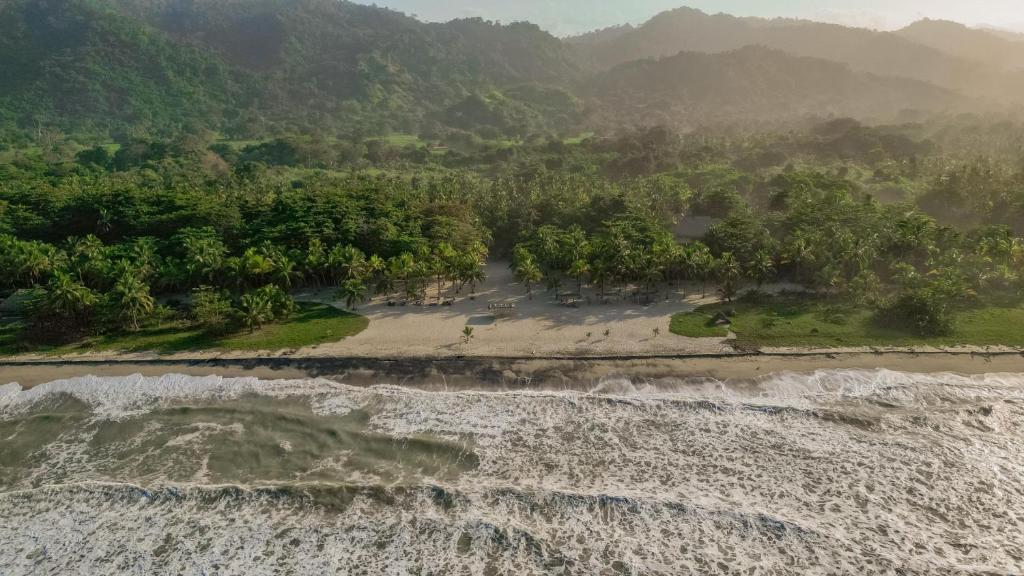 una vista aérea de la playa y del océano en Playa Bonita Hotel EcoCabañas Tayrona en Buritaca