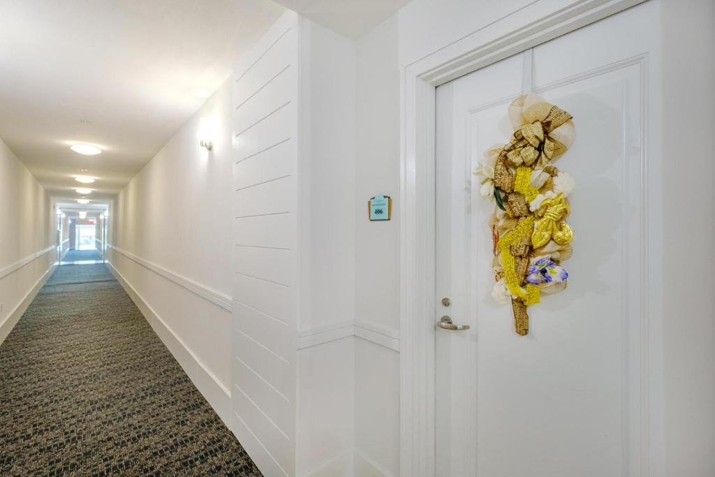 a hallway with a white door with a wreath on it at Ocean Club 406 in Biloxi