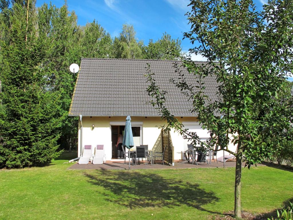 een klein wit huis met een tafel en stoelen bij Holiday Home Möwen und Muschel Nest by Interhome in Ostseebad Karlshagen