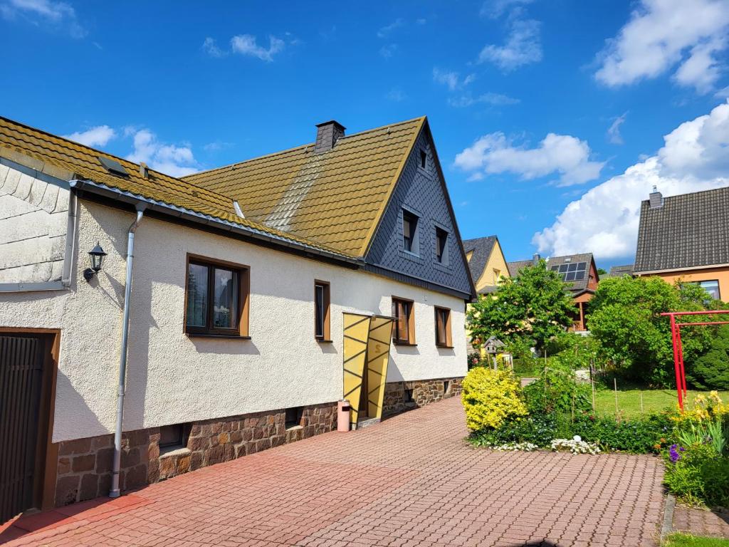 ein Haus mit einem schwarzen Dach und einer steinernen Einfahrt in der Unterkunft Ferienhaus Keppler im Erzgebirge in Sayda