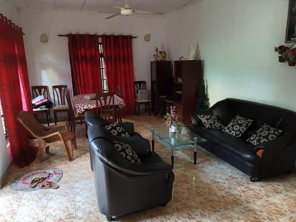 a living room with two black couches and a table at 67 holiday home in Badulla