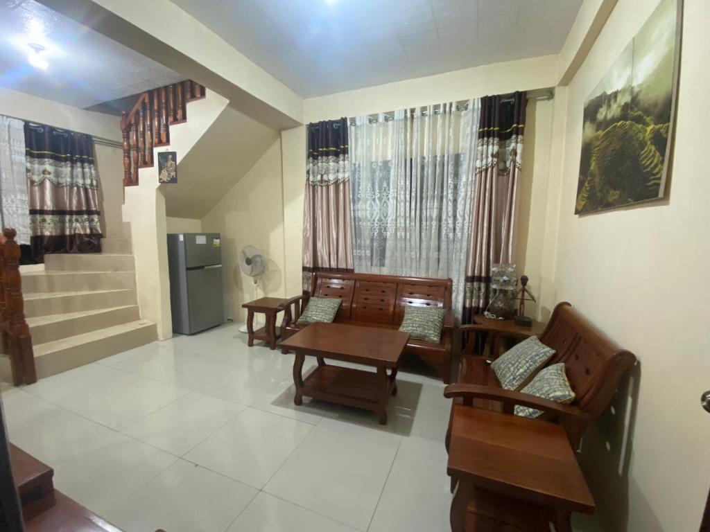 sala de estar con mesa y sillas y escalera en Backpackers hostel and transient house, en Nangalisan