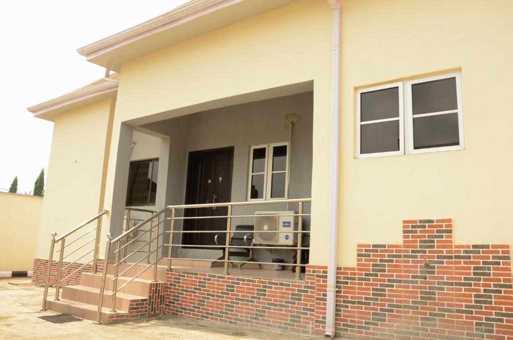 a house with a balcony with a chair on it at Peace cottage short lets and apartments in Ibadan