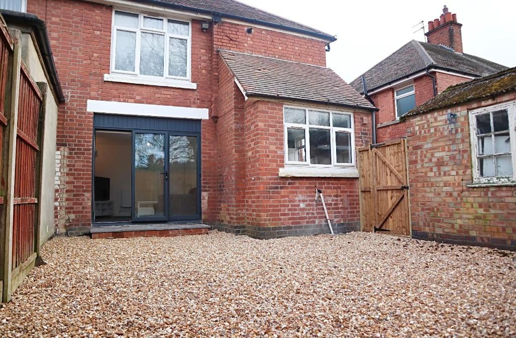 a brick house with a large window and a garage at Large Capacity Comfortable Group Stay in Nottingham