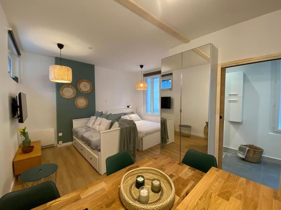 ein Wohnzimmer mit einem Bett und einem Esstisch in der Unterkunft Nid douillet tout équipé in Château-Renault