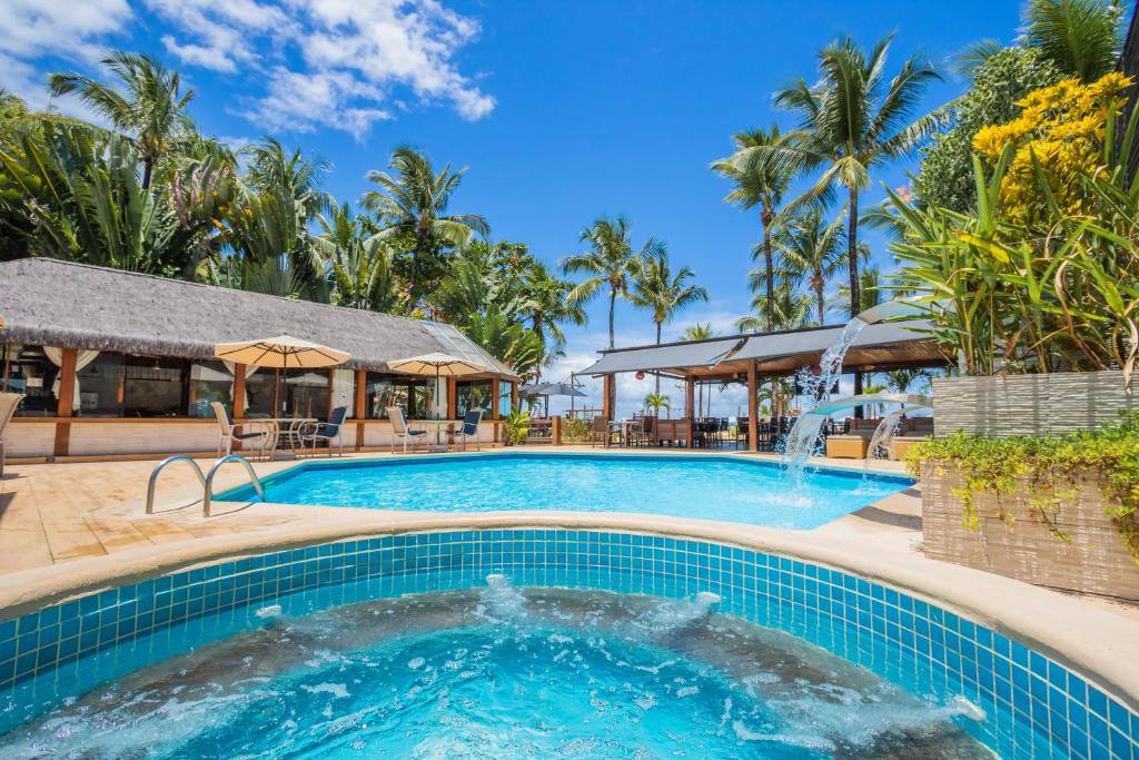 a pool at a resort with a fountain at Pousada da Torre in Morro de São Paulo