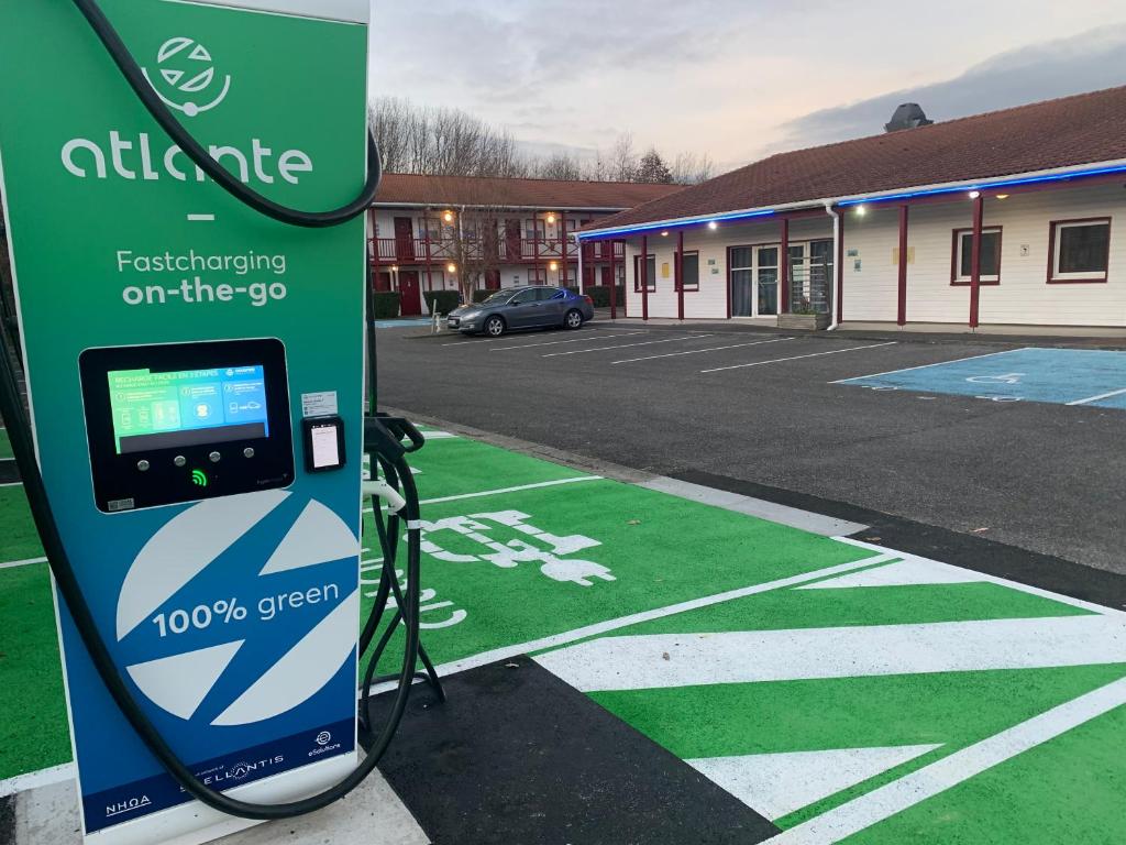 uma estação de carregamento de electricidade em frente a um parque de estacionamento em Everhotel de Tarbes-Ibos em Tarbes