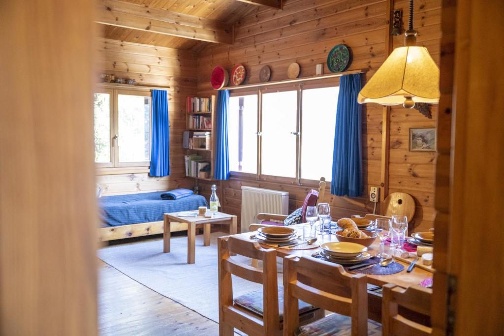 a dining room with a table and a room with a bed at Chasa Avant Porta in Ramosch