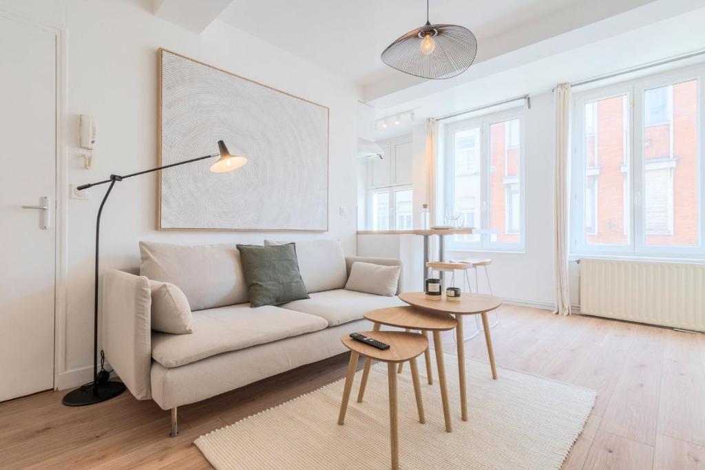 un salon blanc avec un canapé et une table dans l'établissement Beautiful renovated appart in the center of Lille, à Lille