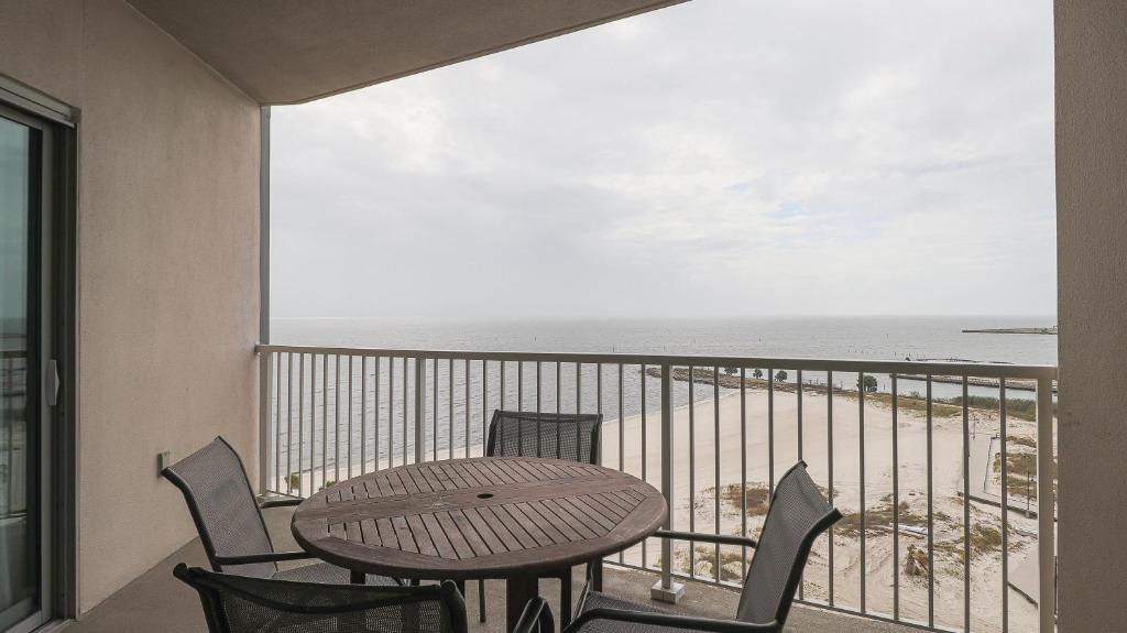 einen Balkon mit einem Tisch, Stühlen und Meerblick in der Unterkunft Sea Breeze 907 in Biloxi