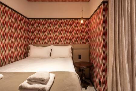 a bedroom with a bed with a red wall at BHomy Consolacao - Estiloso de 2 quartos MR132 in Sao Paulo