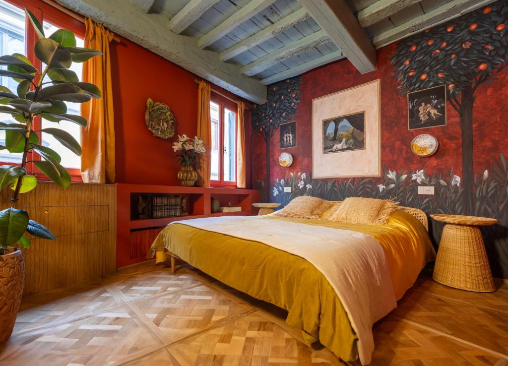 Schlafzimmer mit roten Wänden und einem Bett mit gelber Bettwäsche in der Unterkunft Casa Lilia - Florence in Florenz